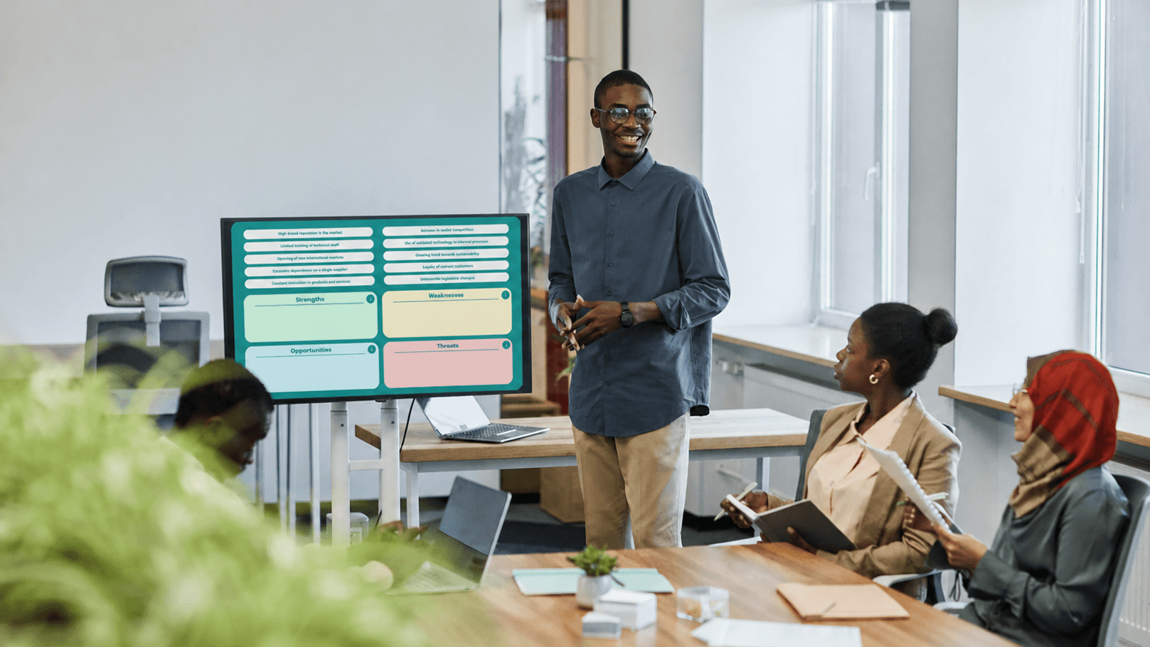 Una reunión de un equipo de ventas compartiendo una creación de Genially sobre SWOT
